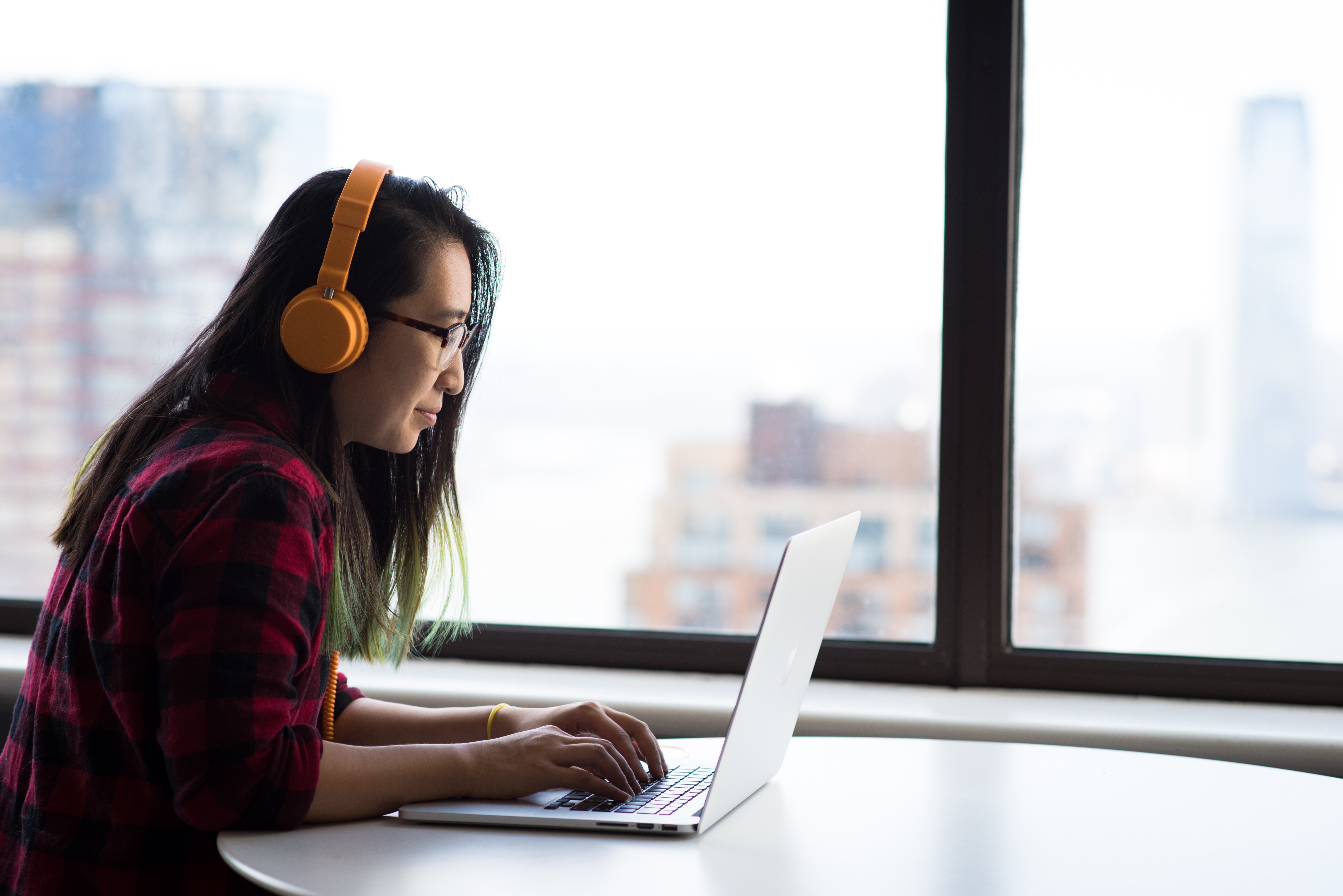 woman wearing headphones working on a laptop